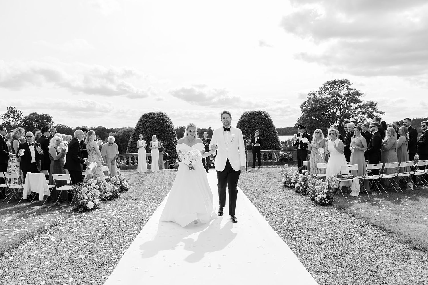 A collection of black and white wedding photographs showing outdoor ceremony and reception moments.
