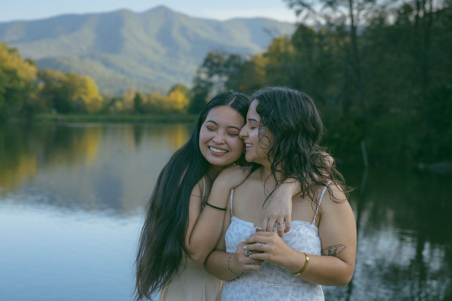 LGBTQ couple holding hands after romantic proposal at blue ridge mountain overlook near Asheville, North Carolina
