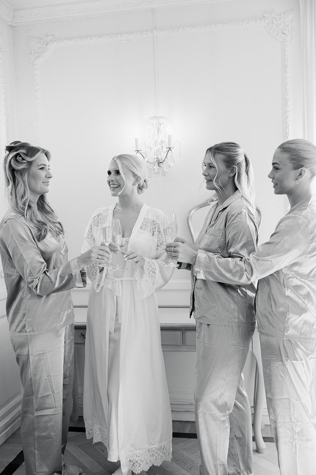 A group in white robes and matching attire getting ready in a bright room with windows.