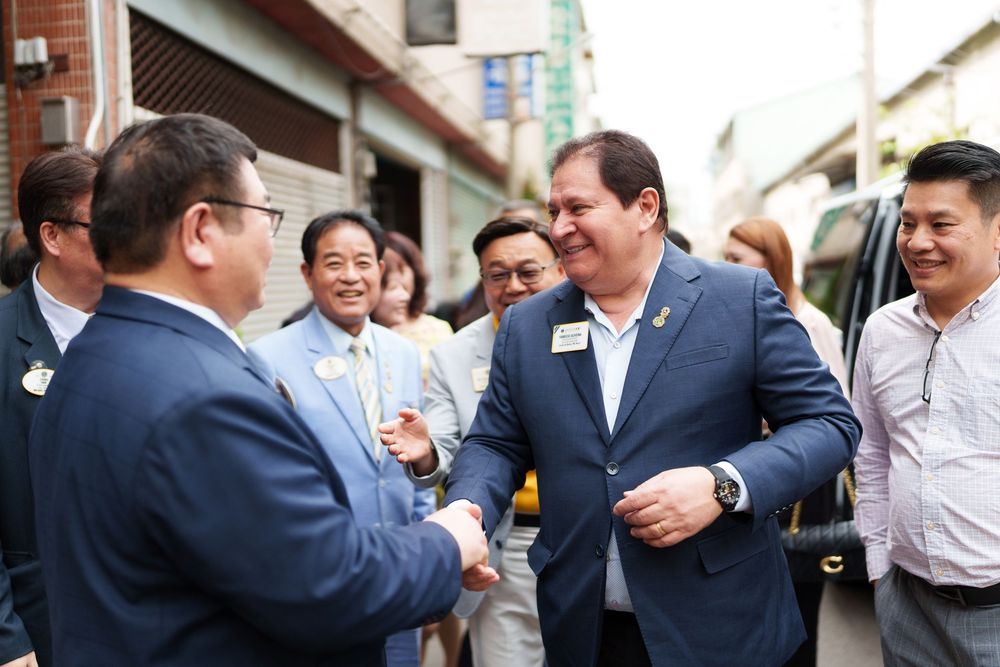Business professionals in suits and formal attire gather for a networking event or reception.