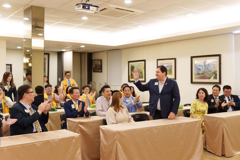 Panoramic view of a business conference room filled with attendees seated at tables during a professional event.