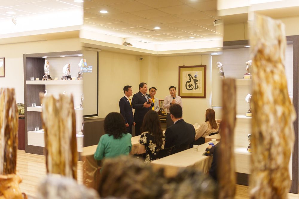 A group gathers in conversation at an elegant indoor venue with warm lighting and decorative wall accents.