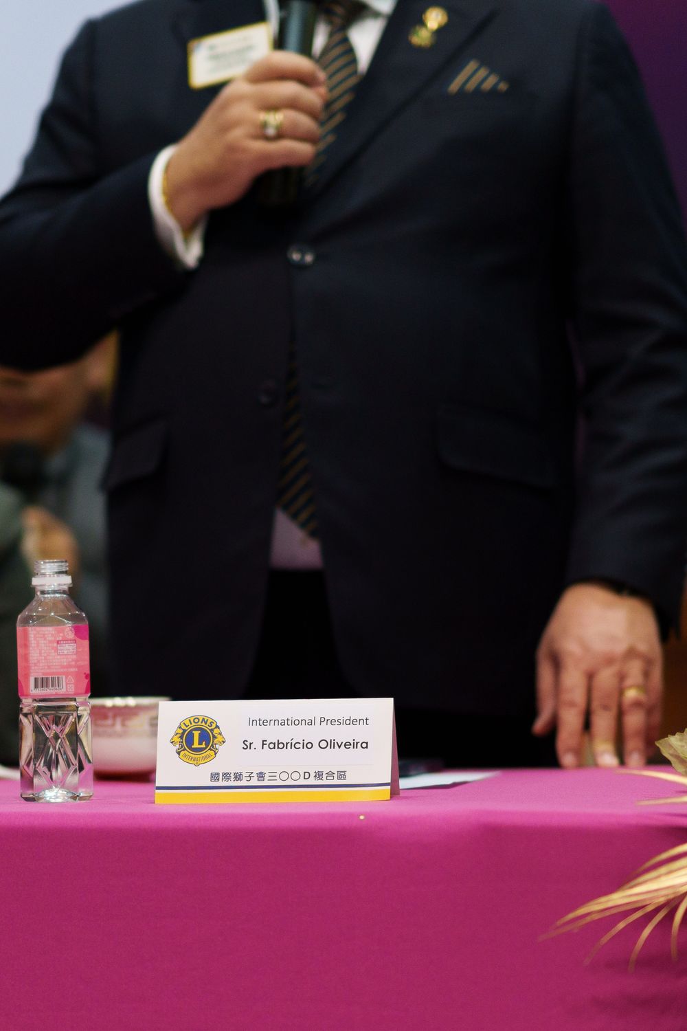 Business meeting setup showing pink tablecloth with water bottles and name placards on conference table.