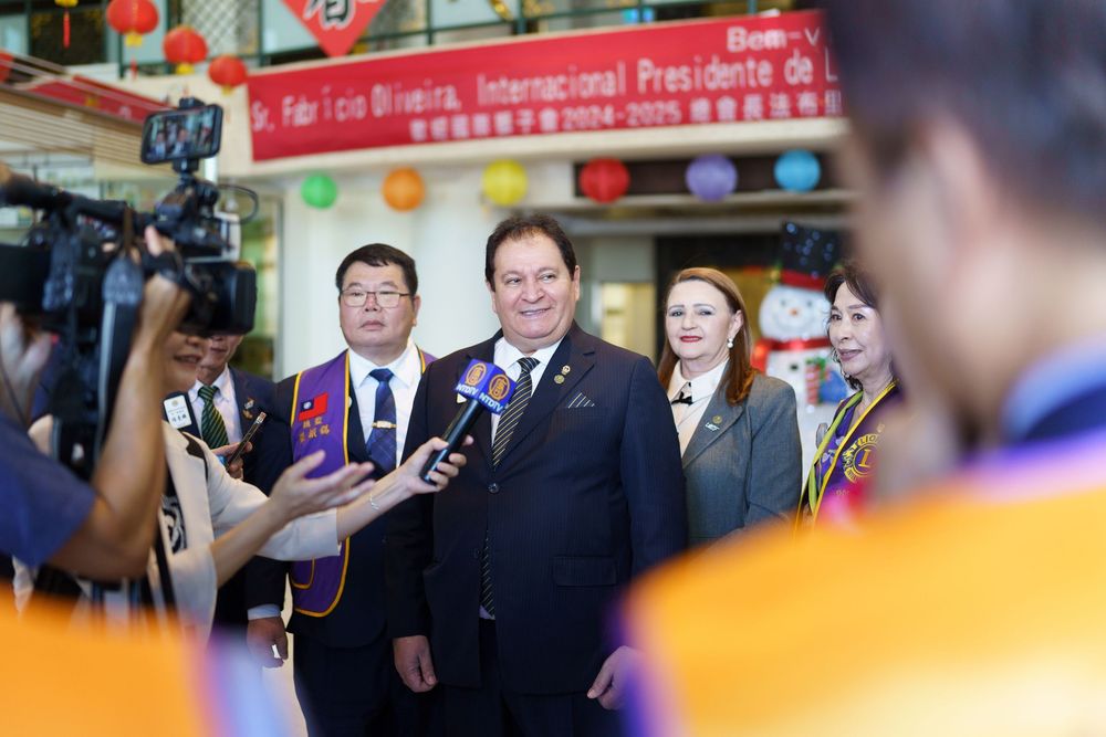 Business executives and officials engage in conversation during an international press conference event.