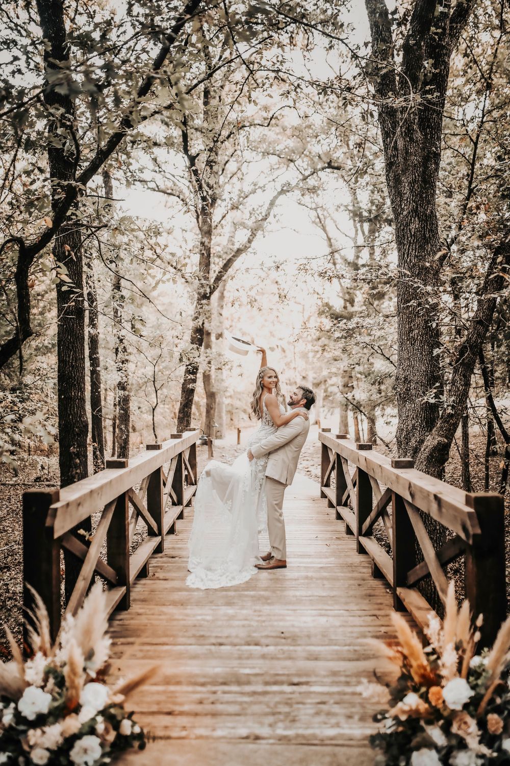 bride and groom celebrate their wedding on the rustic bridge at whispering oaks taken by april pinto photography