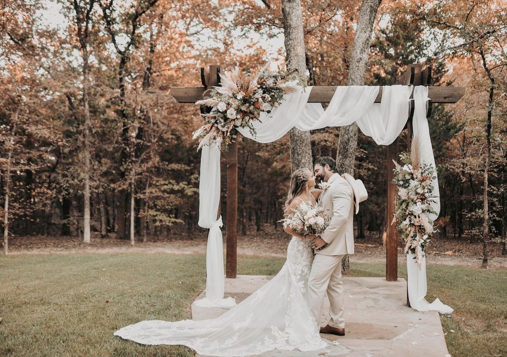 Wedding day portraits of bride and groom at the altar framed by greenery and natural light