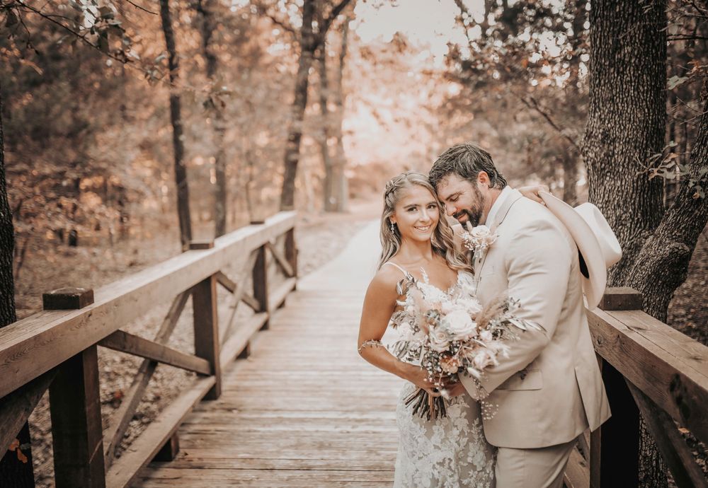 Bride and groom holding hands on the Whispering Oaks altar with rustic greenery and elegant florals