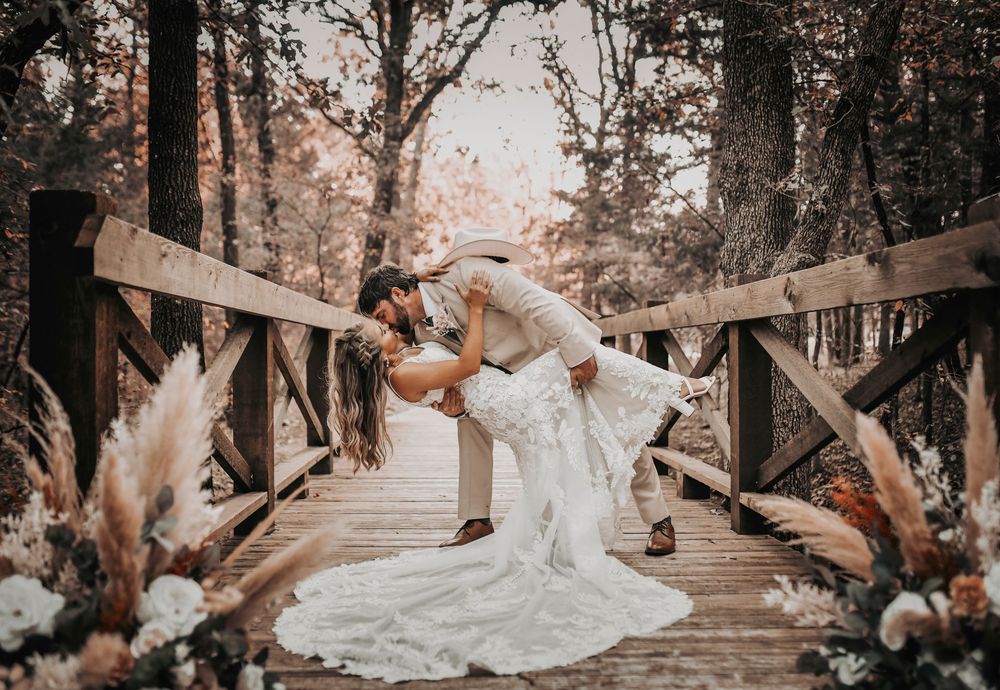 Romantic bride and groom portraits on the rustic wooden bridge at Whispering Oaks wedding venue