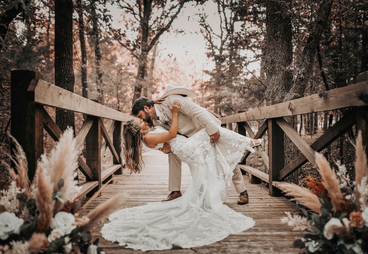 Romantic bride and groom portraits on the rustic wooden bridge at Whispering Oaks wedding venue