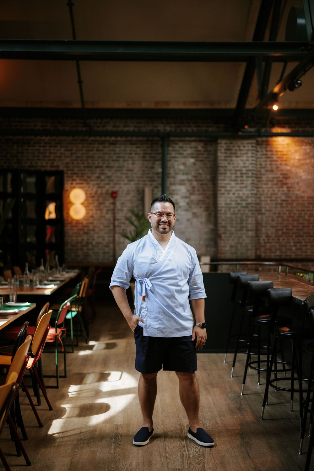 A sequence of photos showing figure in white shirt posing in a dimly lit industrial space with exposed brick walls. Picnic Philadelphia
