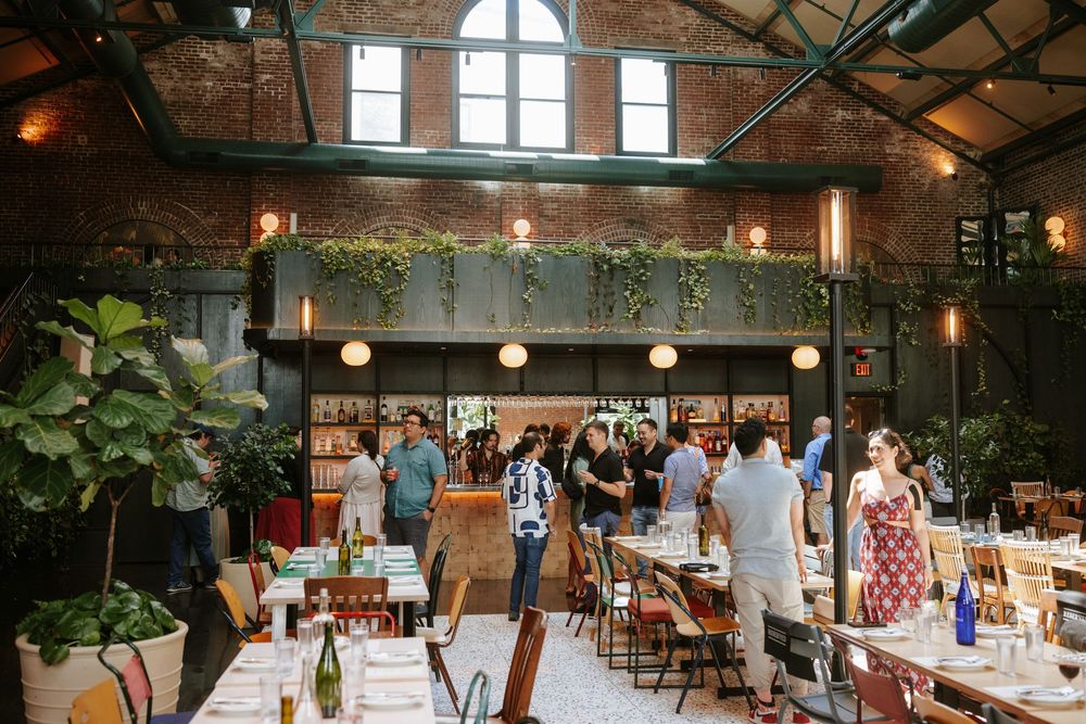 Interior view of a rustic barn venue decorated for an event with long tables and hanging lights creating an elegant atmosphere Picnic Philly