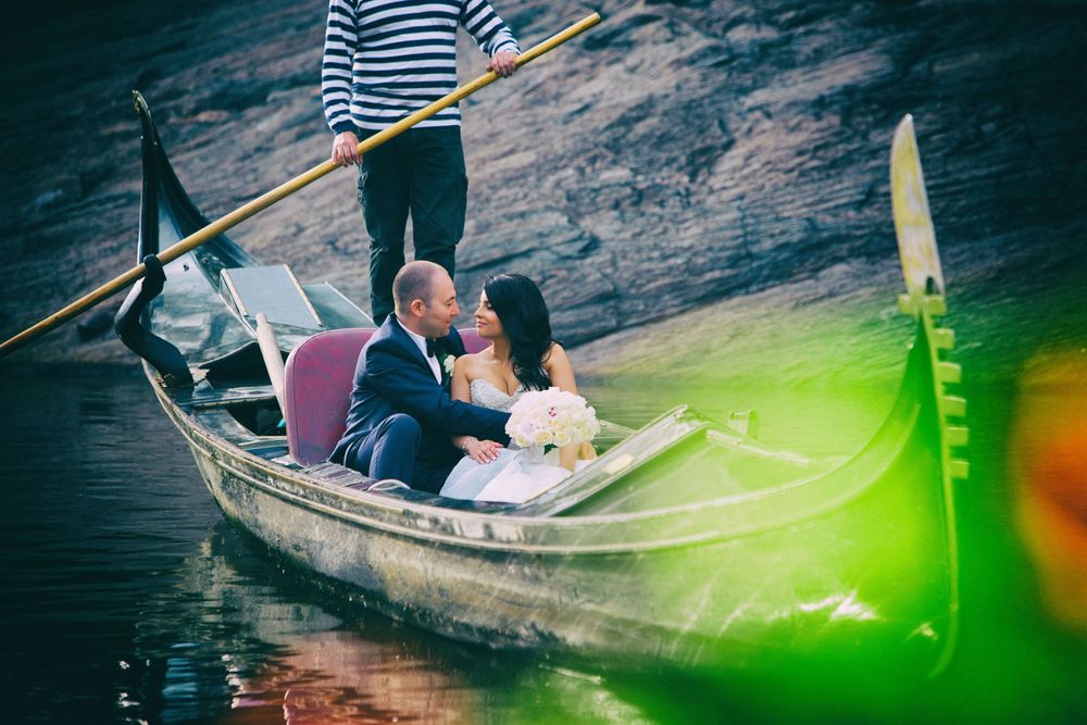 A romantic gondola ride with a traditional gondolier standing at the stern, capturing an intimate moment on the water.