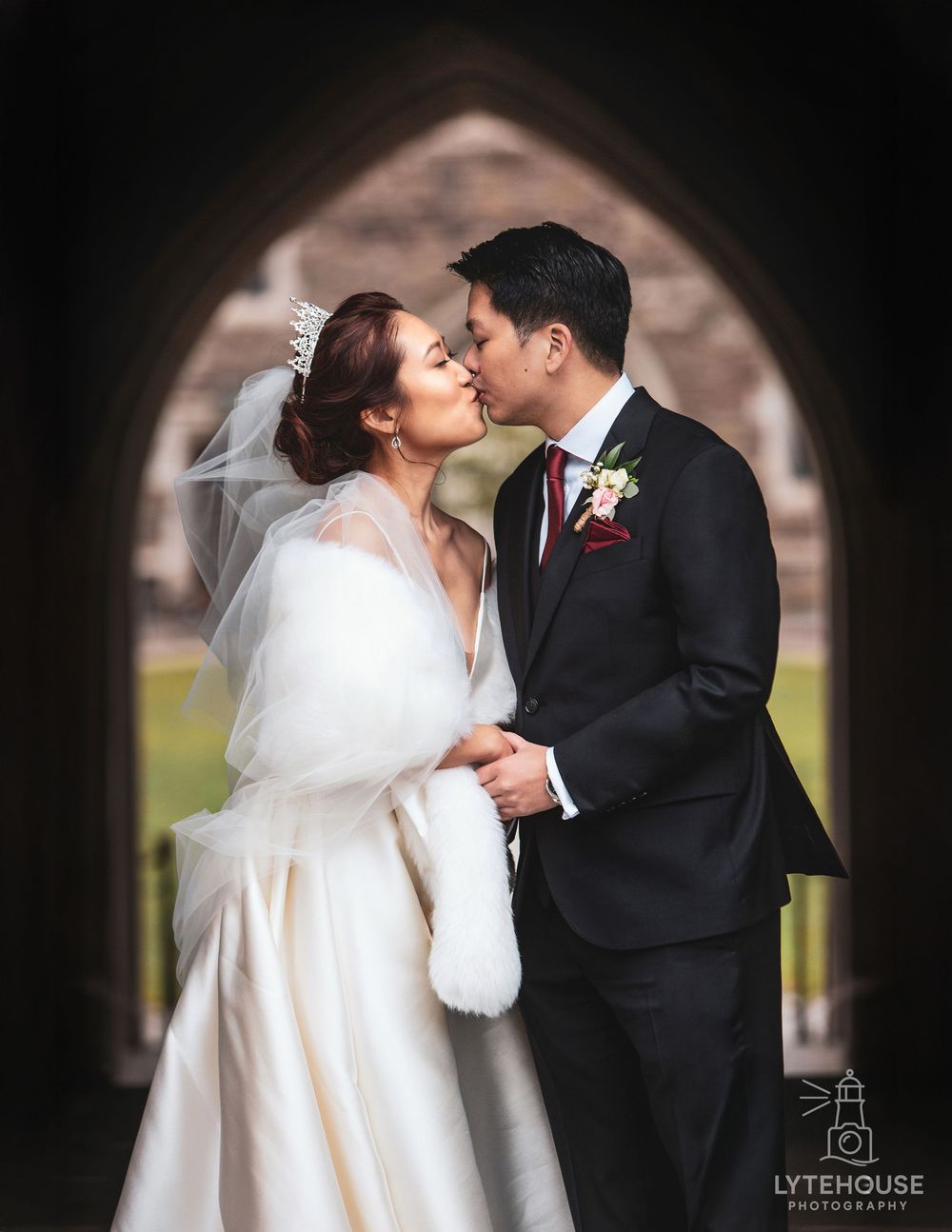 Romantic winter wedding couple sharing intimate kisses in a series of photos while wearing a white fur wrap.