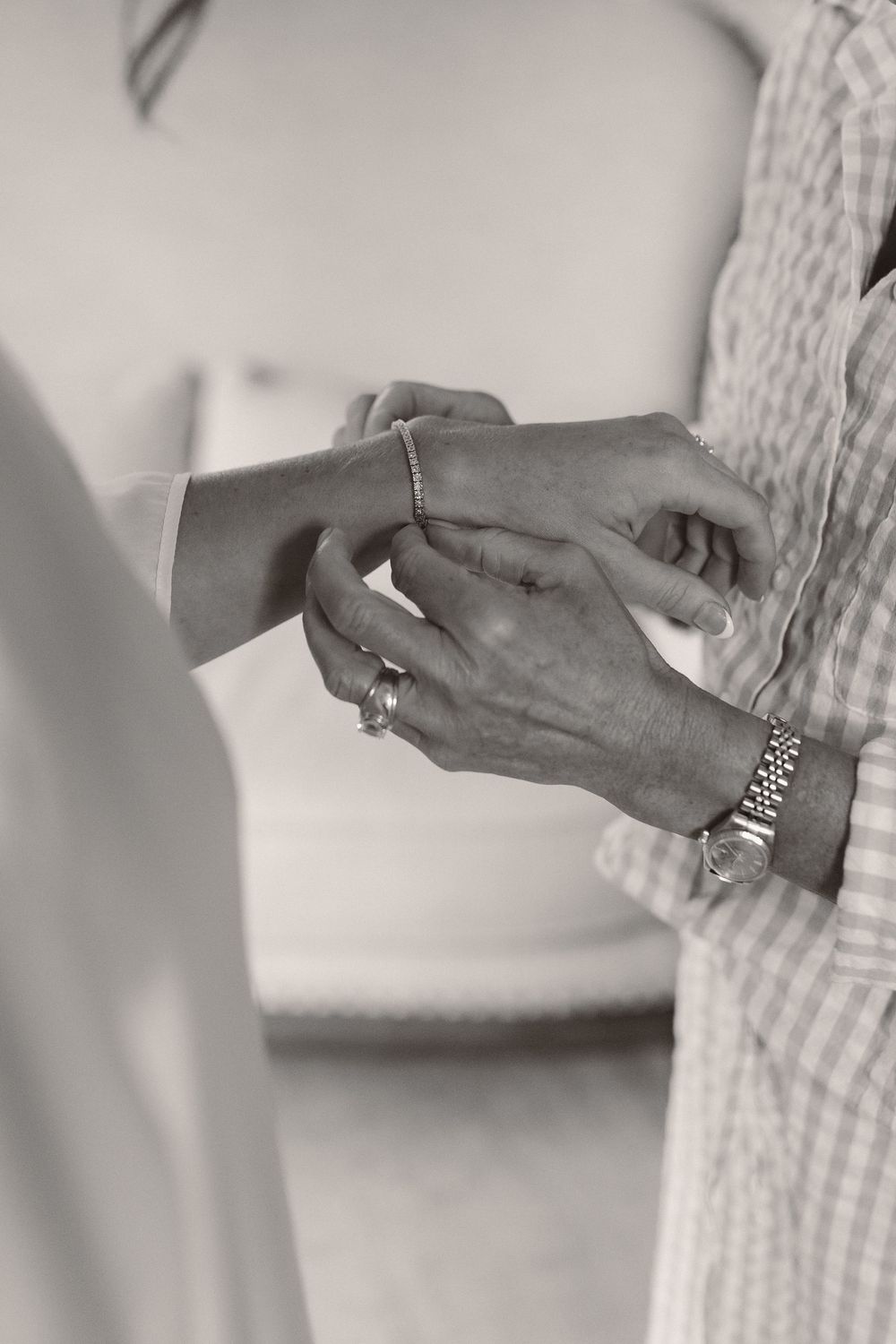 Close up of hands exchanging ring in black and white photography.
