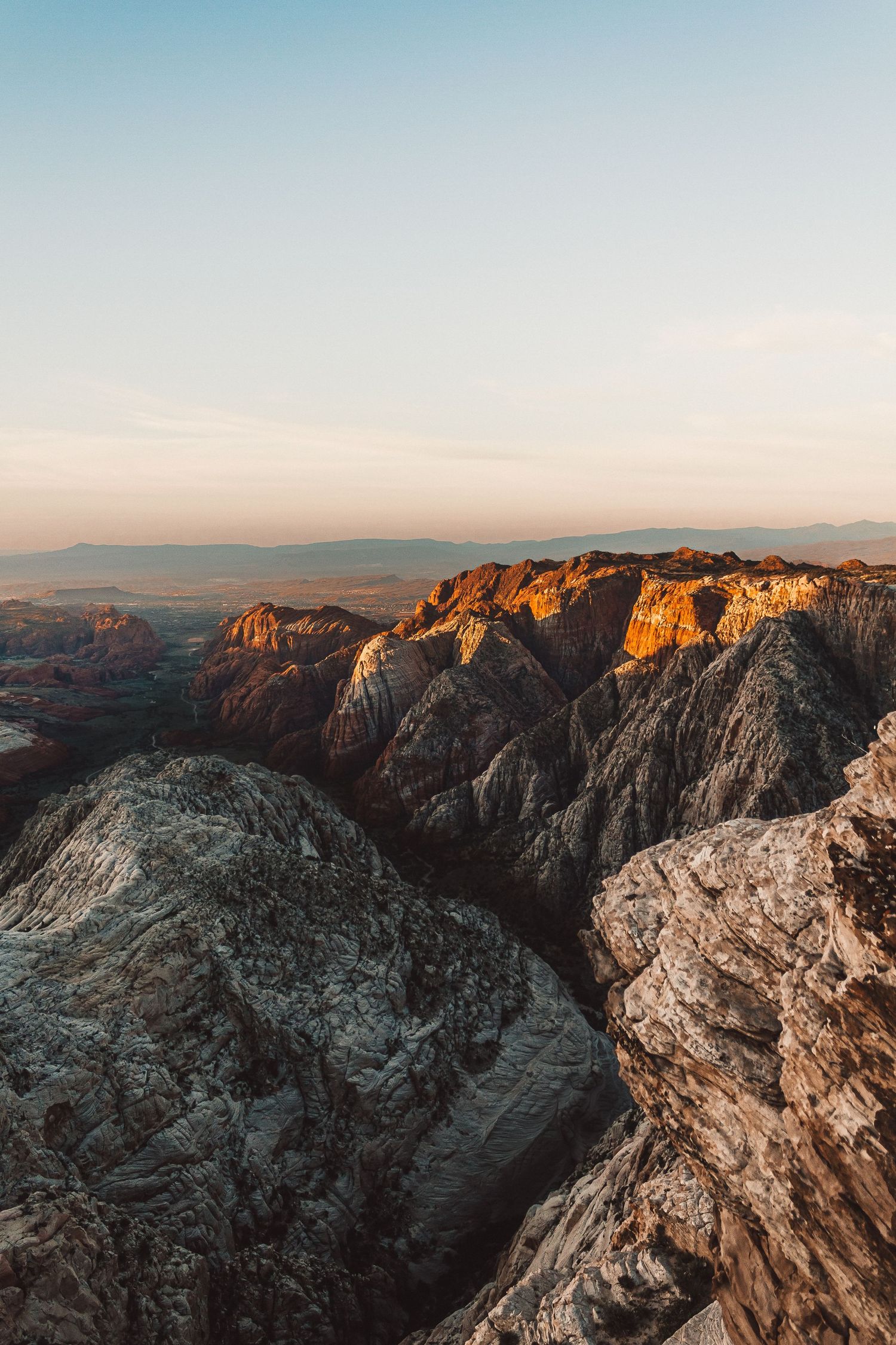 The light of the rising sun hitting the walls of a deep canyon from afar.