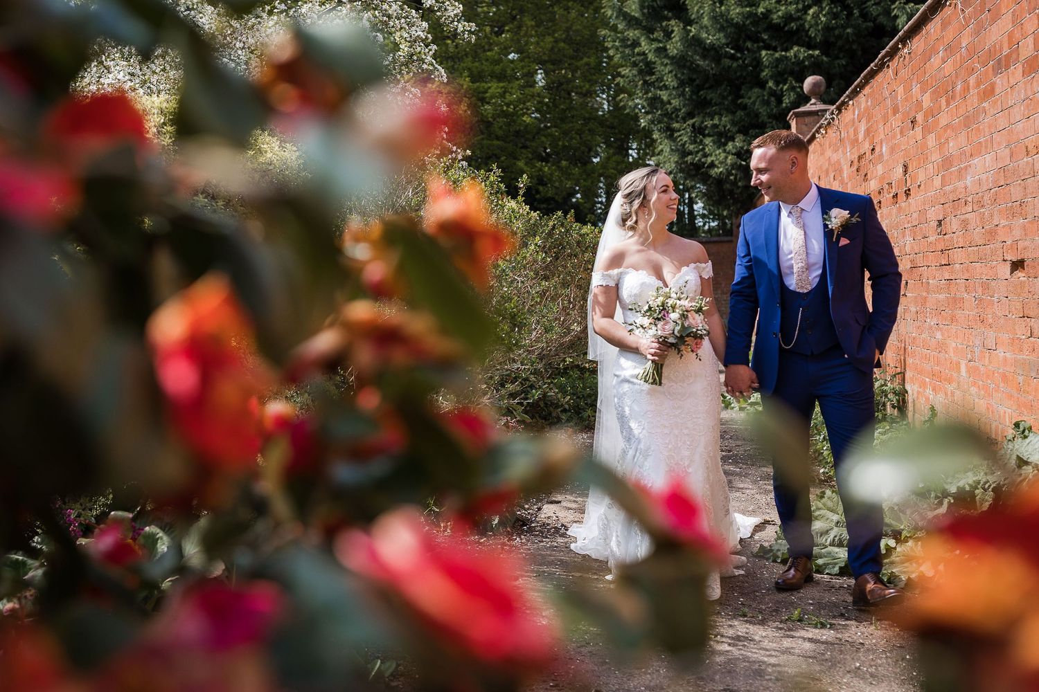 Couple sharing a relaxed laugh at the edge of the walled garden at Kelham House