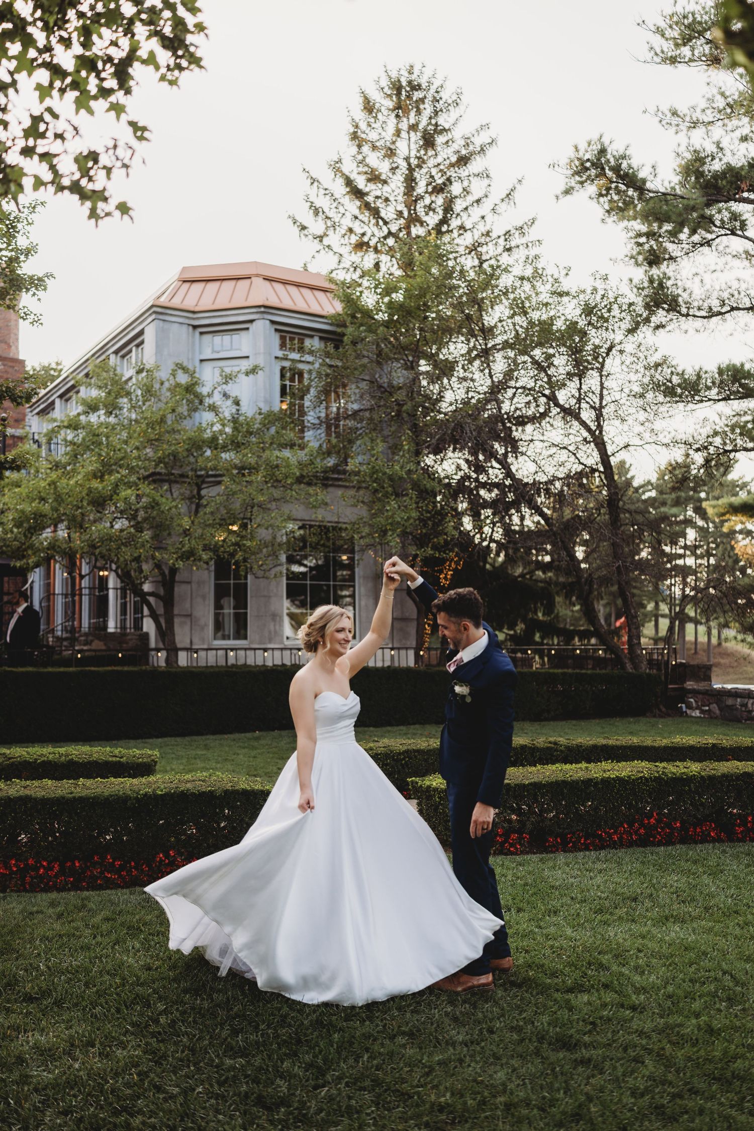 Classic black and white wedding portraits showing a bride in flowing gown and groom in tuxedo outside a stone church.