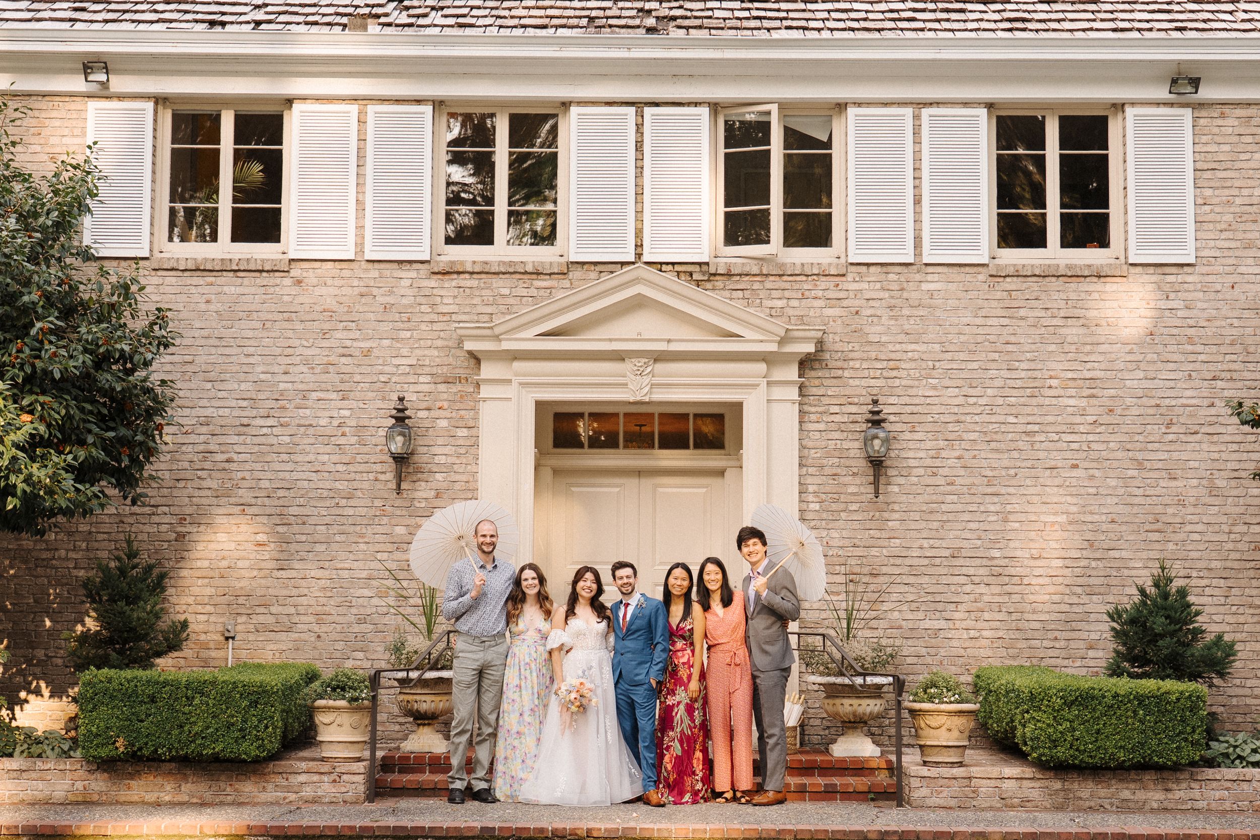 A series of wedding party photos lined up showing elegant outdoor shots against a stone building backdrop.