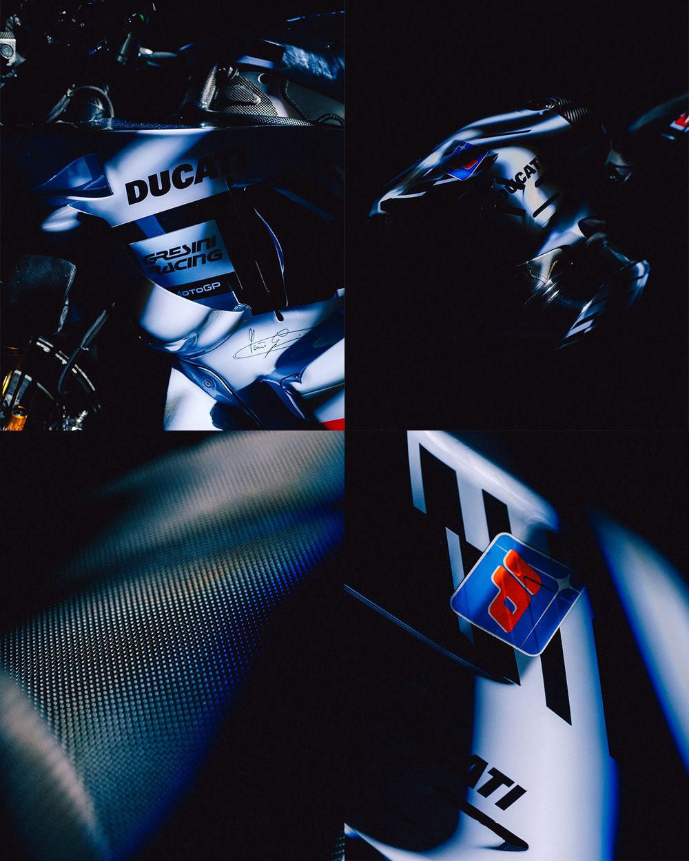 Close-up shots of a sleek blue and white motorcycle in dramatic low-key lighting showing various body panel details.