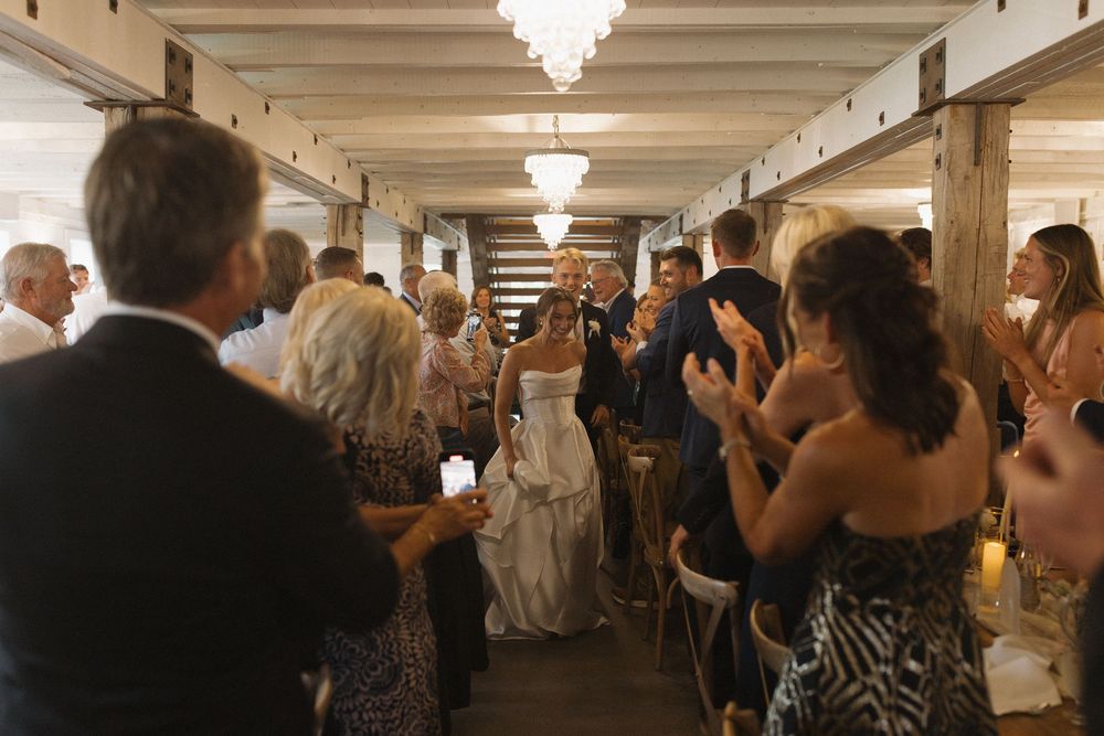 Guests celebrating at a wedding reception in an elegant indoor venue with overhead lighting.