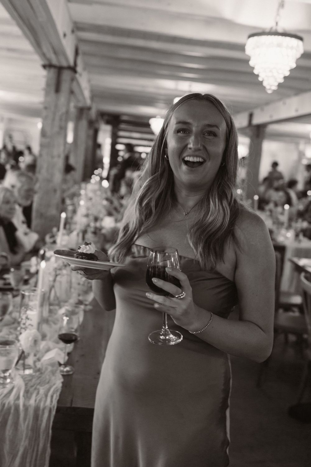 Wedding reception guests enjoying drinks and laughter in an elegant venue.