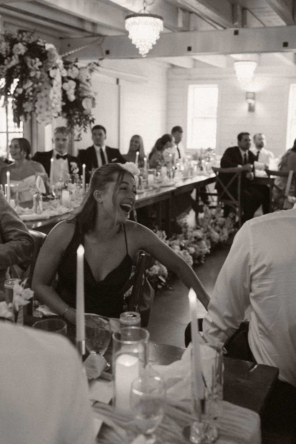 Wedding reception venue with elegant table settings and crystal chandeliers.
