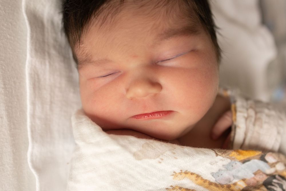 Series of peaceful sleeping newborn against soft white fabric.