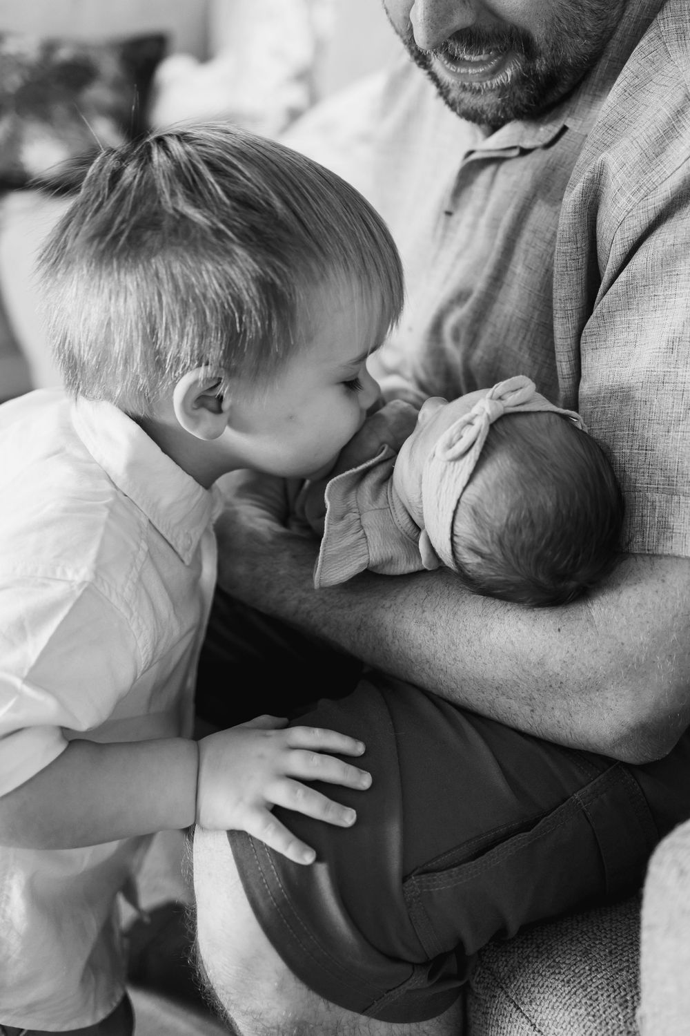 Black and white intimate family moment with newborn and sibling.