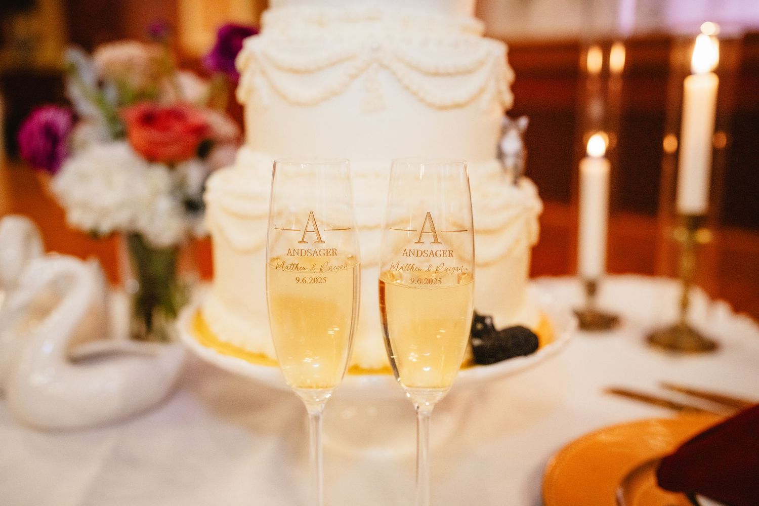 Elegant wedding reception tables decorated with glowing candles and white floral centerpieces at sunset.
