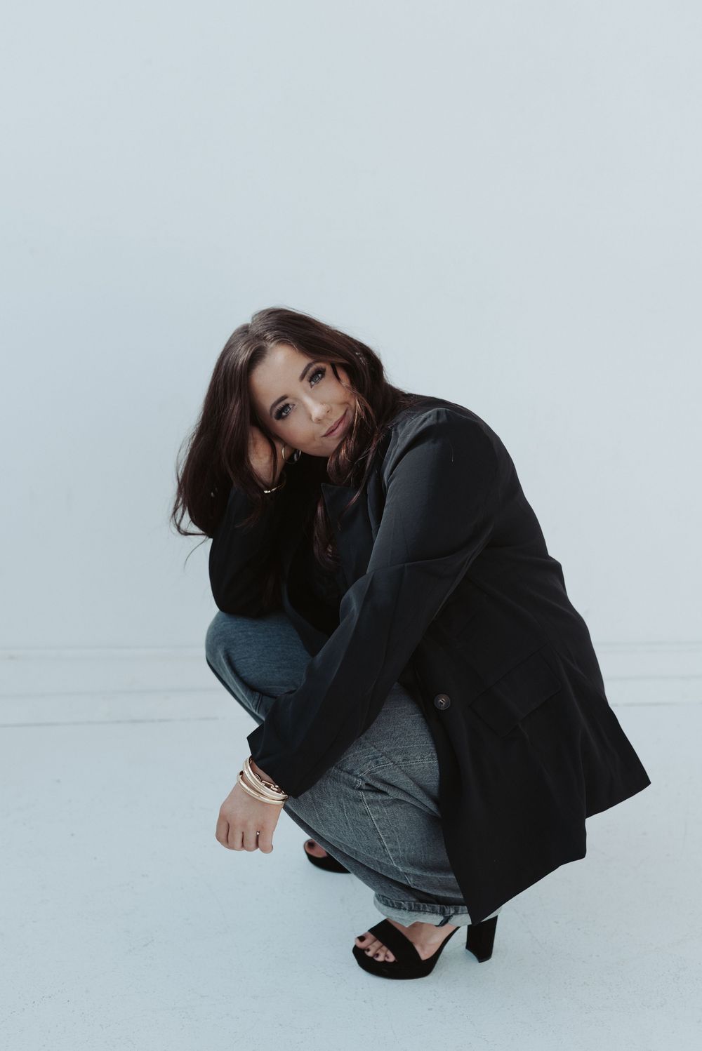Dynamic low-angle poses in black and denim outfit against white background.