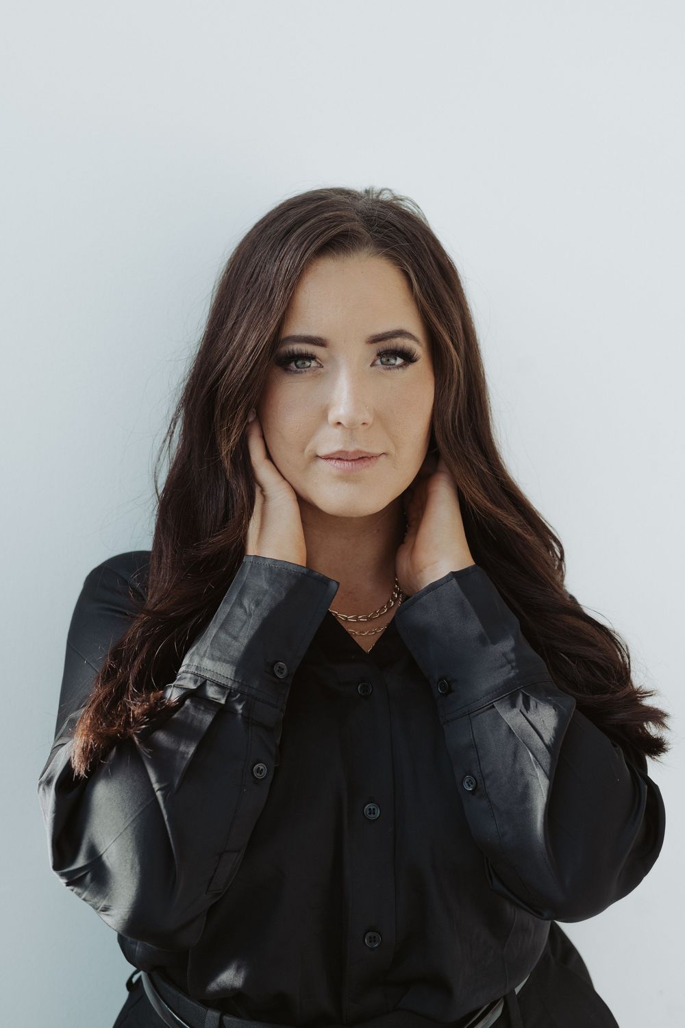 A series of expressive portrait poses in black clothing against a white background.