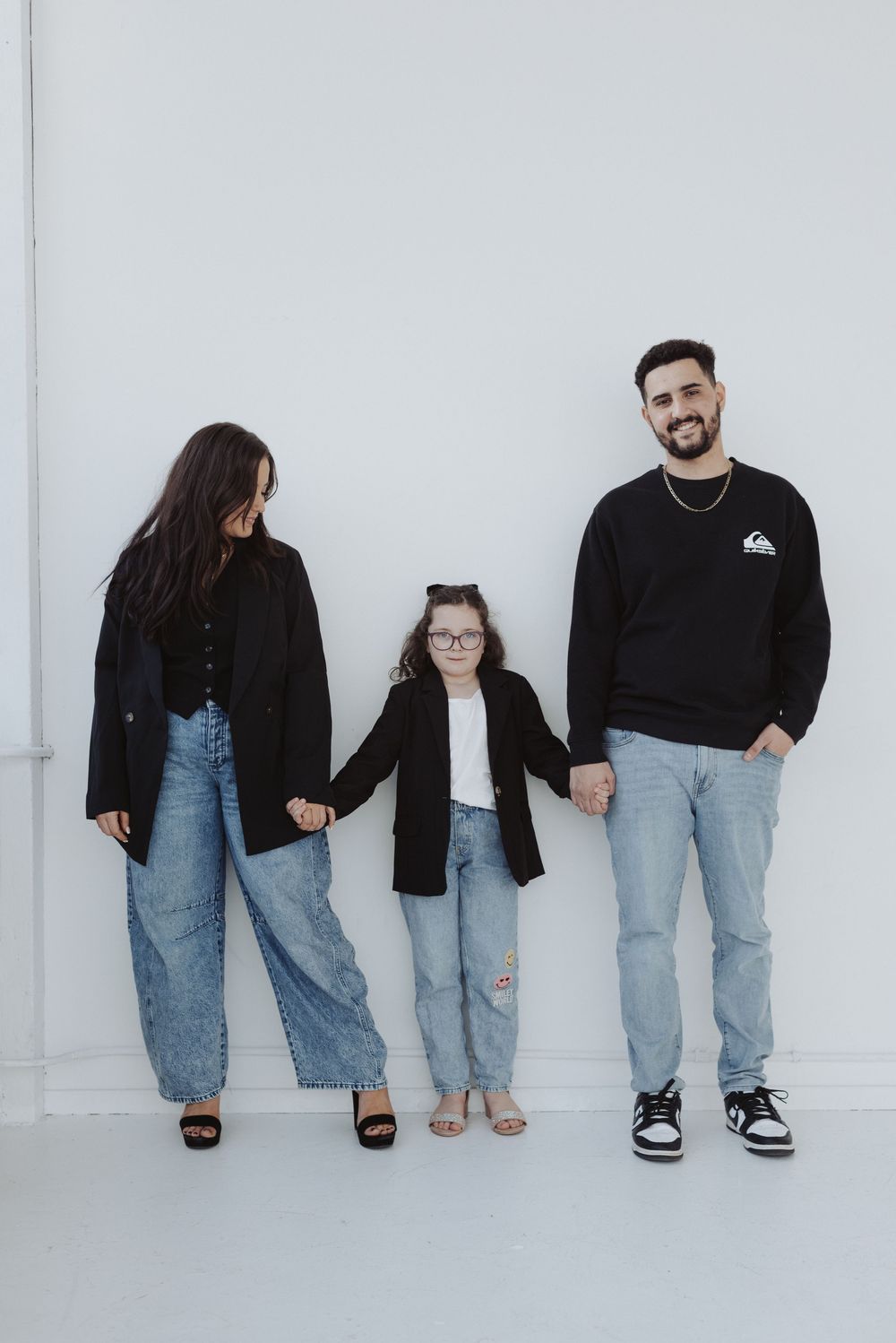 Two people in coordinated outfits standing against white backdrop showing different poses.