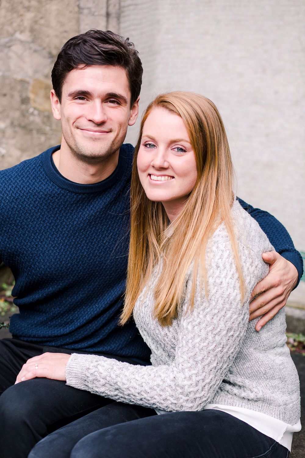 Couple in navy and white sweaters share intimate moments while sitting together.