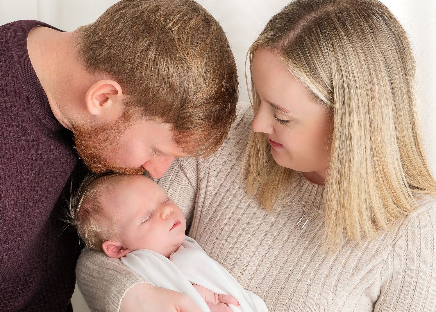 Intimate family moment captured on a cosy couch indoors.