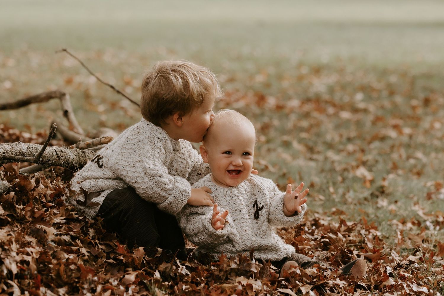 Autumn baby photography session with fallen leaves and natural tones.
