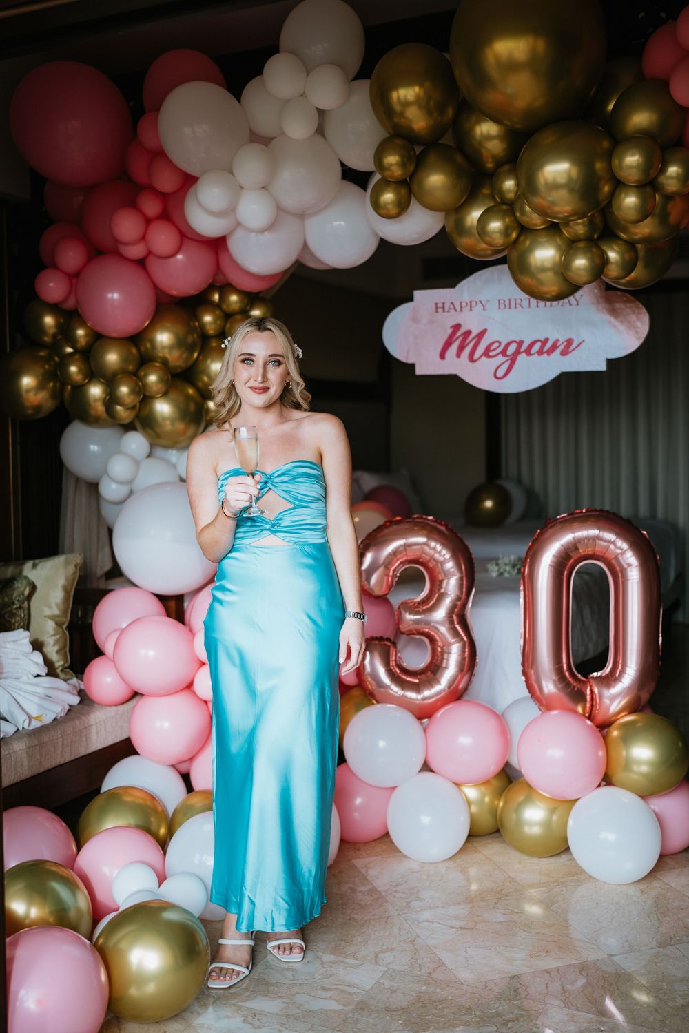 Birthday celebration setup with pink and gold balloons featuring number decorations.