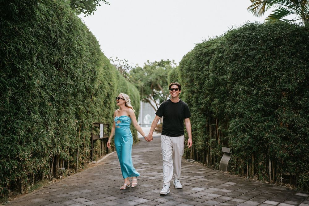 Tree-lined pathway creates a natural tunnel effect in a tropical garden.