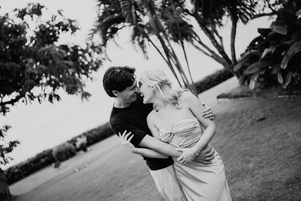 Black and white romantic moment captured in an outdoor garden setting.