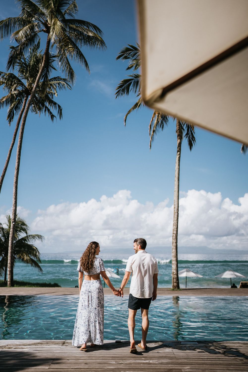 Couple sharing a romantic moment by an infinity pool overlooking the ocean.