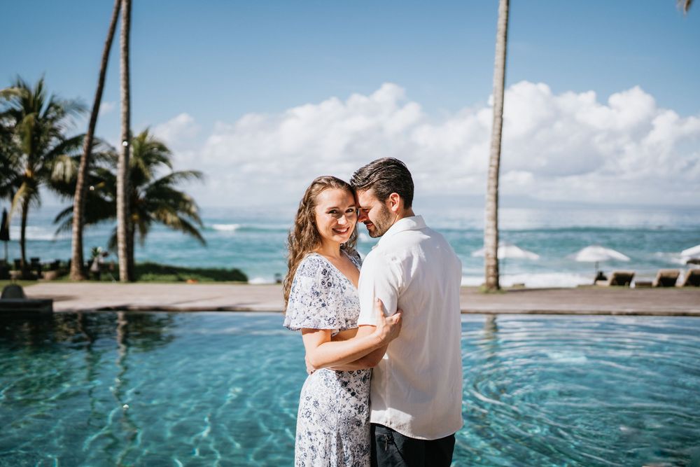 Romantic scene by an infinity pool with tropical ocean views and swaying palms.