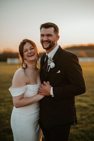 Golden hour wedding portraits in front of a rustic farm setting.