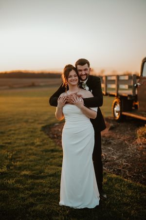 Romantic sunset photos of newlyweds in a rustic farm setting.