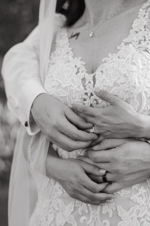 Close-up black and white photos showing hands exchanging wedding rings during a ceremony.