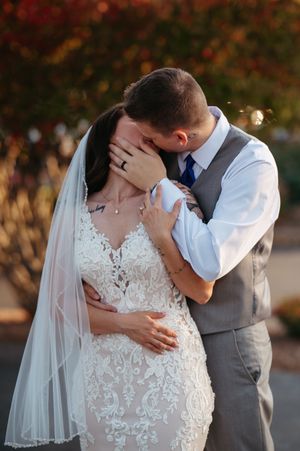 A romantic wedding couple shares an intimate kiss during their golden hour photo session outdoors.