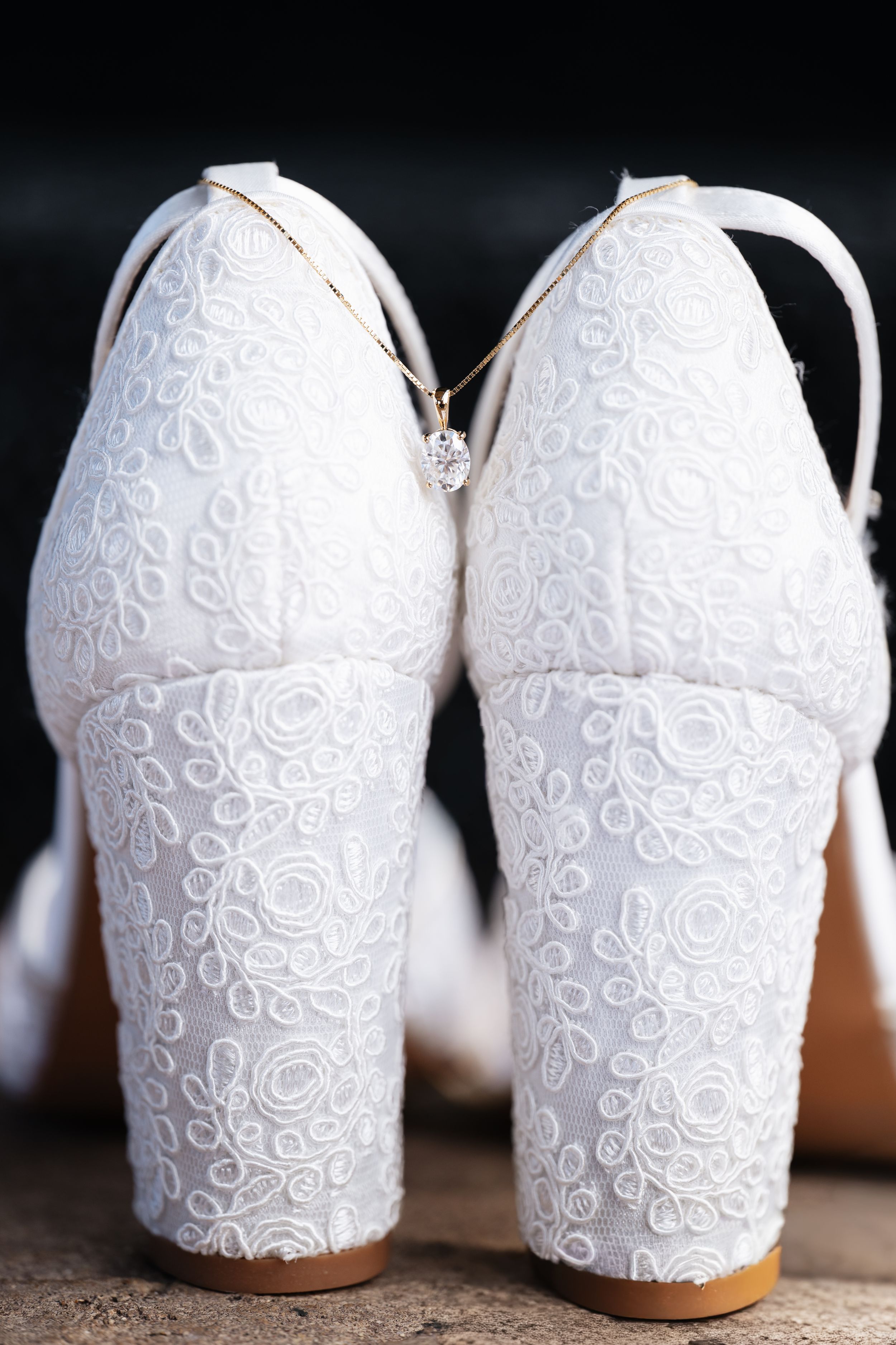 A series of white ceramic vases with intricate lace-like patterns shown from different angles on a dark background.