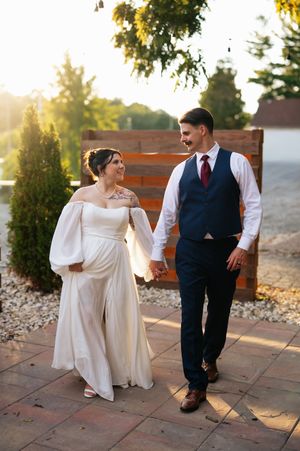 Couple sitting on wooden bench in romantic engagement photo session during golden hour at sunset.