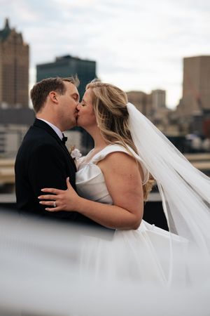 A sequence of romantic wedding photos showing a couple kissing with a city skyline in the background.
