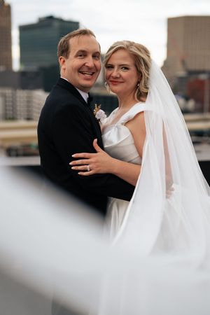 Multiple frames capture tender moments between newlyweds with urban architecture visible behind them.