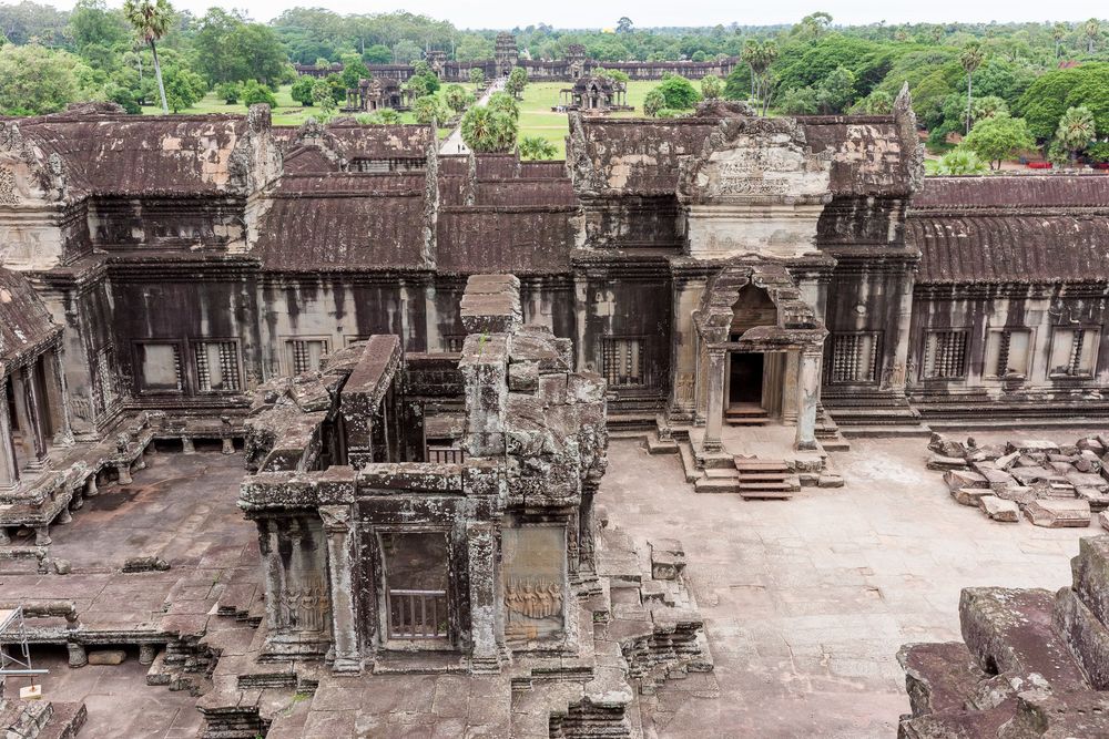 Ancient stone corridors and carved pillars stretch through the historic temple ruins of Angkor Wat in Cambodia.