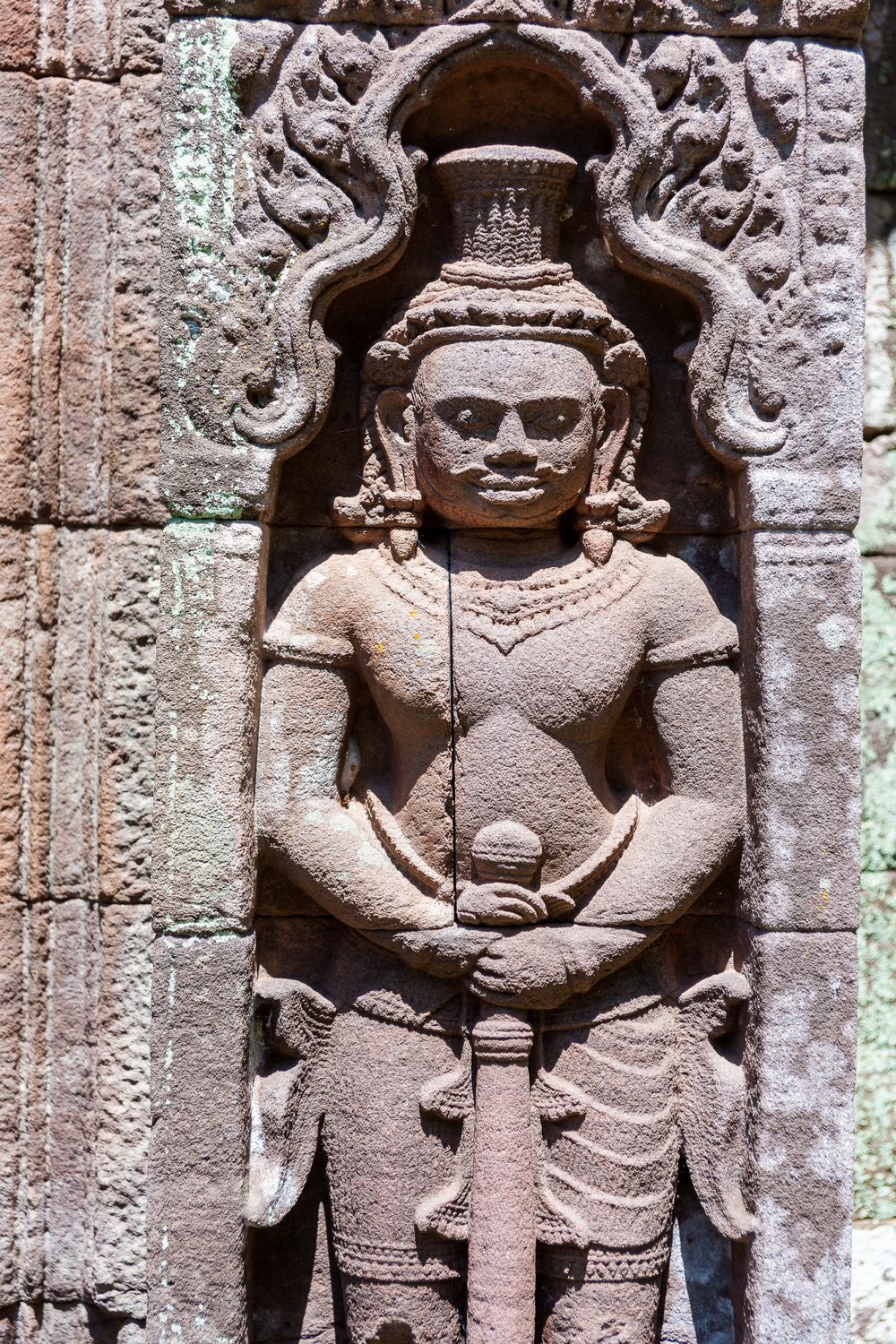 Ancient stone carvings depicting ornate figures and decorative details on temple walls at Angkor Wat in Cambodia.